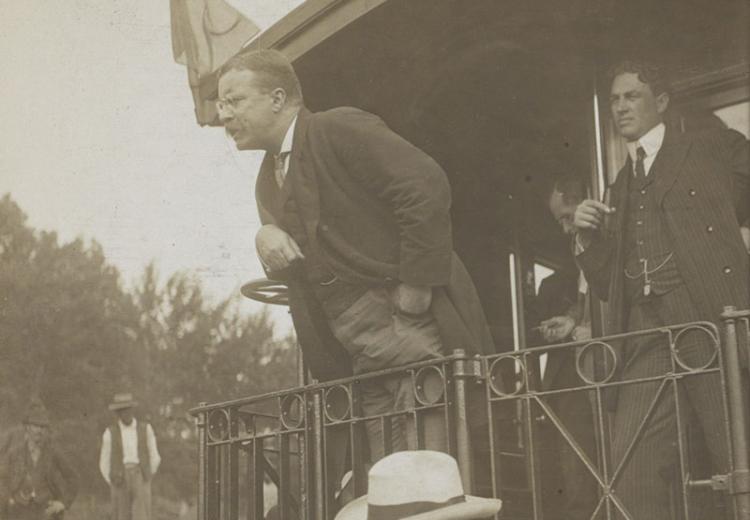 Teddy Roosevelt speaking at the back of a railroad car.